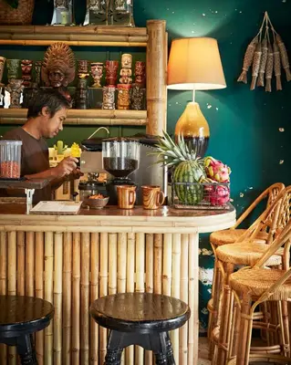 a man sitting at a bar with a drink at Motu Bangkok in Bangkok