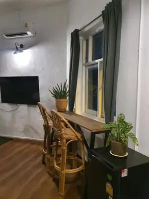 a room with a table and chairs and a television at Motu Bangkok in Bangkok