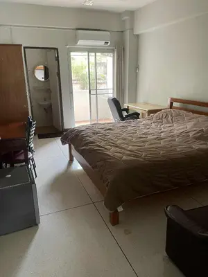 a bedroom with a bed and a table and chairs at Viriyapon2 in Bangkok