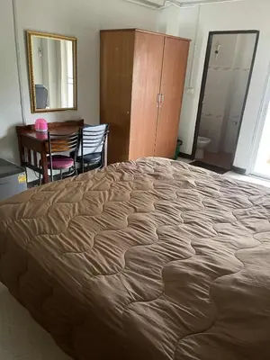 a bedroom with a large bed and a desk and chair at Viriyapon2 in Bangkok