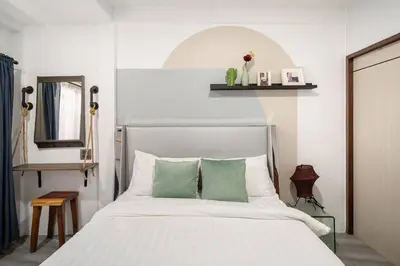 a bedroom with a white bed with green pillows at Spacious 4BR Family Chatuchak Market 12 sleeps in Bangkok