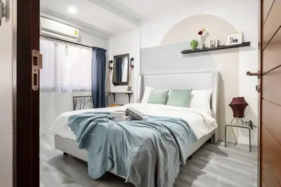 a bedroom with a white bed with a blue blanket at Spacious 4BR Family Chatuchak Market 12 sleeps in Bangkok