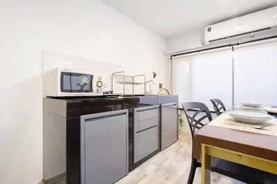 a kitchen with a dining table and a microwave at Spacious 4BR Family Chatuchak Market 12 sleeps in Bangkok