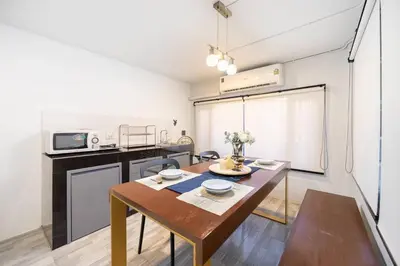 a small kitchen with a wooden table and a dining room at Spacious 4BR Family Chatuchak Market 12 sleeps in Bangkok