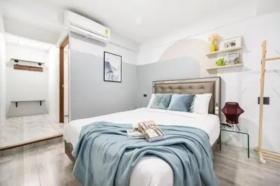 a bedroom with a bed with a blue blanket at Spacious 4BR Family Chatuchak Market 12 sleeps in Bangkok
