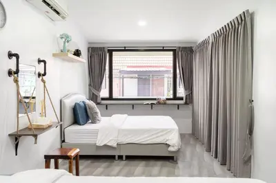 a bedroom with two beds and a window at Spacious 4BR Family Chatuchak Market 12 sleeps in Bangkok