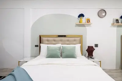 a bedroom with a large white bed with green pillows at Spacious 4BR Family Chatuchak Market 12 sleeps in Bangkok
