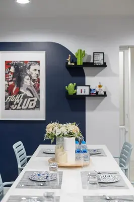 a dining room with a white table and blue walls at Spacious 4BRTownhouse BTS Onnut 10 Sleeps with Parking in Amphoe Phra Khanong