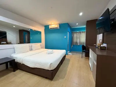 a hotel room with a bed and a blue wall at Bed By Cruise Hotel At Samakkhi-Tivanont in Nonthaburi