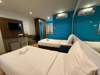 a hotel room with two beds and a blue wall at Bed By Cruise Hotel At Samakkhi-Tivanont in Nonthaburi