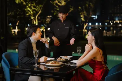 a group of people sitting around a table at a restaurant at Ten Six Hundred, Chao Phraya, Bangkok by Preference, managed by The Ascott Limited in Bangkok