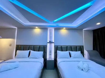 two beds in a room with a blue ceiling at DiscoveryHome3 at Pratunammarket in Bangkok