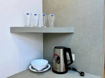 a coffee maker on a counter with glasses on a shelf at DiscoveryHome3 at Pratunammarket in Bangkok