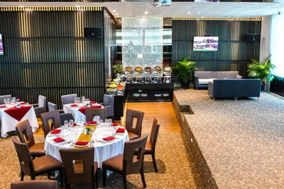 a restaurant with tables and chairs and a bar at Hotel Royal Bangkok in Bangkok