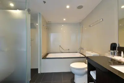 a bathroom with a tub and a toilet and a sink at Hotel Royal Bangkok in Bangkok