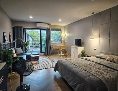 a bedroom with a bed and a living room at AndStay in Bangkok