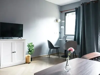a living room with a vase with a flower on a table at AndStay in Bangkok
