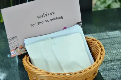 a basket with a sign and a tablet in it at NORN Riverside Bangkok Hotel - นอนริมน้ำ in Bangkok