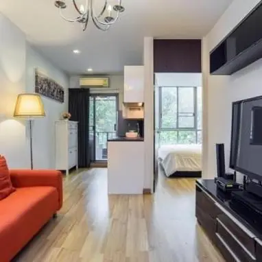 a living room with a couch and a television in it at Vinn condo in Amphoe Phra Khanong