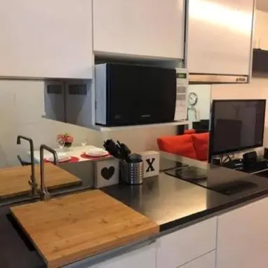 a kitchen with a counter with a sink and a microwave at Vinn condo in Amphoe Phra Khanong