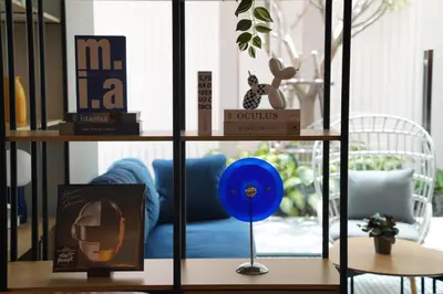 a shelf with books and a blue couch in a room at View Place Hotel & Residence Lat Phrao 130 in Bangkok