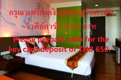 a bedroom with a white bed with avertisement at Happyland Mansion in Bangkok