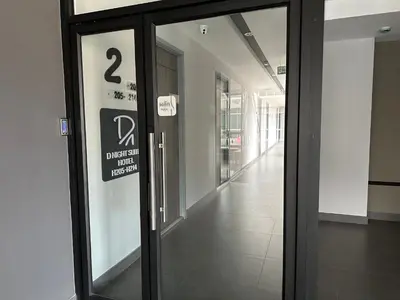 a glass door in a building with a sign on it at D Night Suite Hotel in Bangkok