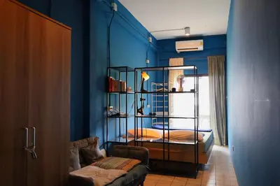 a bedroom with blue walls and a room with a bed at El Biografo in Bangkok