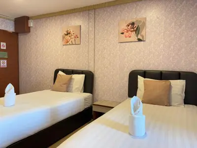 two beds in a hotel room with two bedsitures at OYO 75446 Travis Inthamara 49 in Bangkok