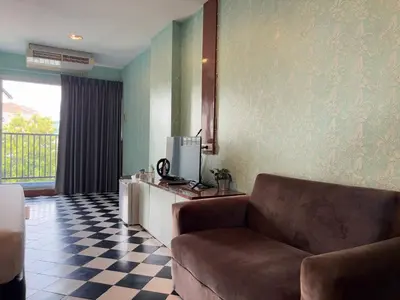 a living room with a couch and a tv at OYO 75446 Travis Inthamara 49 in Bangkok