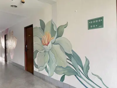 a painting of a flower on a wall at OYO 75446 Travis Inthamara 49 in Bangkok