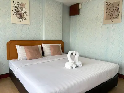 a bed with two white swans sitting on it at OYO 75446 Travis Inthamara 49 in Bangkok