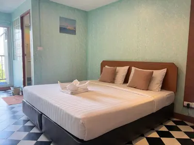 a bedroom with a large bed with two candles on it at OYO 75446 Travis Inthamara 49 in Bangkok