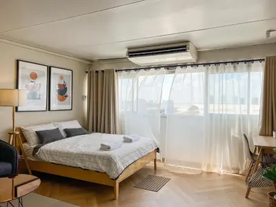 a bedroom with a bed and a large window at Better Room ห้องพักรายวัน เมืองทองธานี C5 in Nonthaburi
