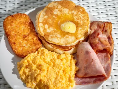 a plate of breakfast food with eggs bacon and toast at Charlie House Pin Klao in Bangkok
