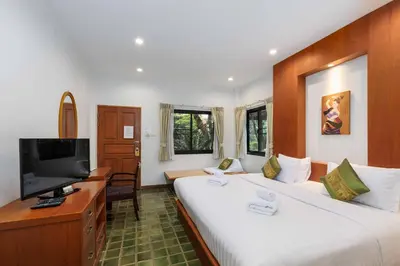a hotel room with two beds and a flat screen tv at Charlie House Pin Klao in Bangkok