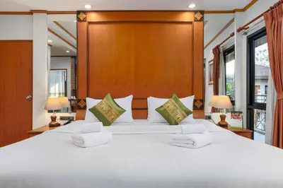 a bedroom with a large white bed with two lamps at Charlie House Pin Klao in Bangkok