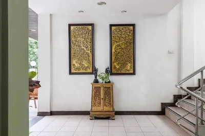 a hallway with two pictures on the wall and a table at Charlie House Pin Klao in Bangkok