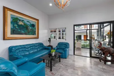 a living room with blue couches and a painting at Charlie House Pin Klao in Bangkok