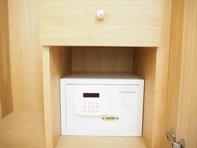 a white microwave in a cabinet with a wooden wall at NANA BEST INN HOTEL in Makkasan