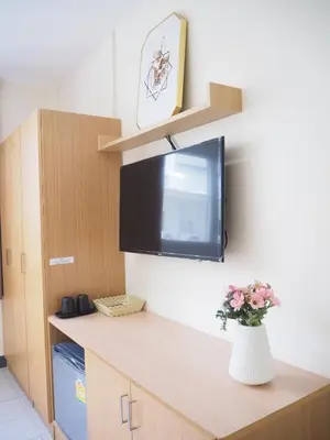 a kitchen with a tv and a vase of flowers at NANA BEST INN HOTEL in Makkasan