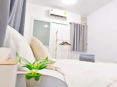 a bedroom with a white bed with a potted plant at Getaway Villa Bangkok - 4 Bedroom,6 Beds and 5 Bathroom in Bangkok