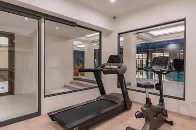 a gym with two elliptical machines and a window at Pranakorn Heritage Hotel in Bangkok
