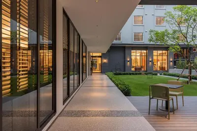 a hallway of a building with a table and chairs at Pranakorn Heritage Hotel in Bangkok