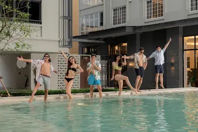 a group of people standing in the water in a swimming pool at Pranakorn Heritage Hotel in Bangkok