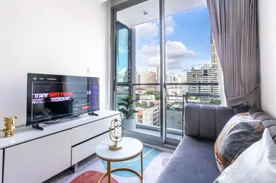 a living room with a tv and a large window at Hyde Sukhumvit 11 Branded Suites in Bangkok