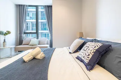 a bedroom with a large bed with pillows on it at Hyde Sukhumvit 11 Branded Suites in Bangkok
