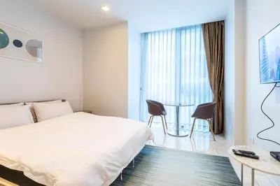 a bedroom with a bed and a table and chairs at Hyde Sukhumvit 11 Branded Suites in Bangkok