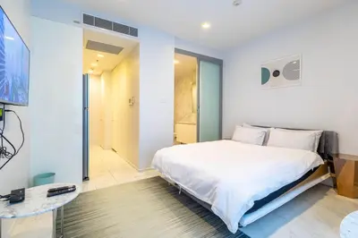 a bedroom with a bed and a walk in shower at Hyde Sukhumvit 11 Branded Suites in Bangkok