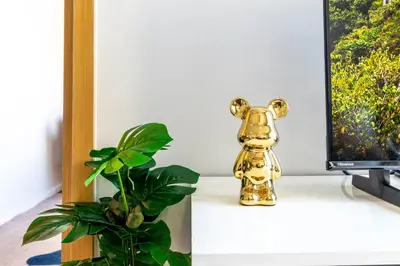 a gold dog toy sitting on a desk next to a plant at Hyde Sukhumvit 11 Branded Suites in Bangkok